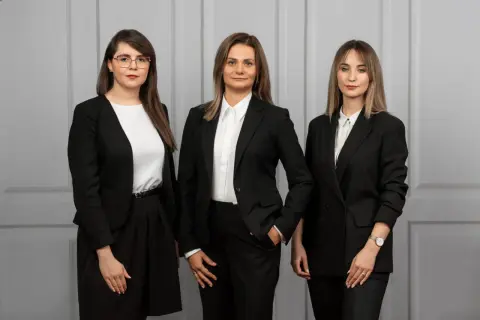 Trzy kobiety w czarnych garniturach. Zastanawiasz się, ile bierze adwokat za reprezentowanie w sądzie?