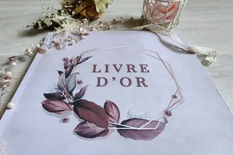Livre d'or orné de feuillages et fleurs, entouré d'une guirlande perlée. Une belle idée pour remplir un livre d'or de souvenirs précieux.