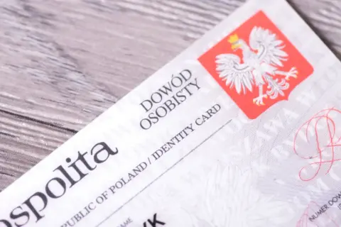 Zbliżenie na polski dowód osobisty, widoczny herb z orłem. Idealne proporcje zdjęcia do dowodu.