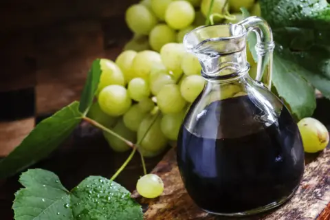 Ciemny płyn w karafce i winogrona. Szukasz, czym zastąpić ocet balsamiczny? Oto inspiracja.