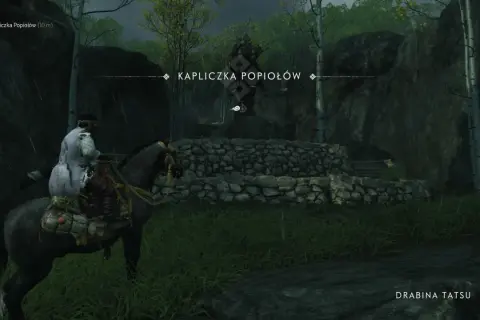 Samuraj na koniu zbliża się do Kapliczki Popiołów, ukrytej wśród drzew i skał.