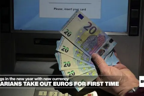 Ręka trzyma banknoty 20 euro przy bankomacie. Bułgarzy po raz pierwszy wypłacają nową walutę.