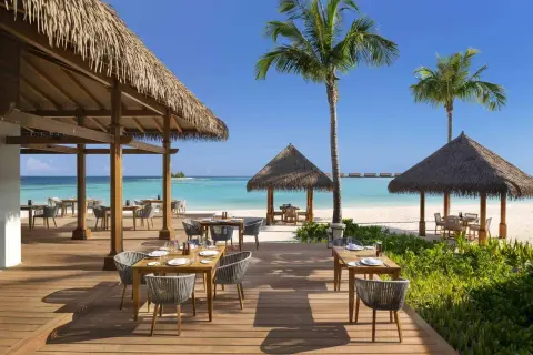Idealna pogoda na Malediwach w styczniu: słoneczny dzień, turkusowa woda i restauracja na plaży.