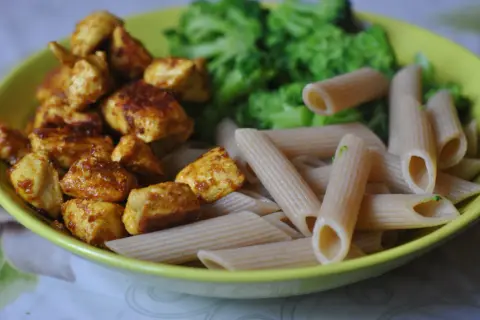 Szybkie przepisy na dania w 15 minut: kurczak w przyprawach, makaron penne i brokuły na talerzu.