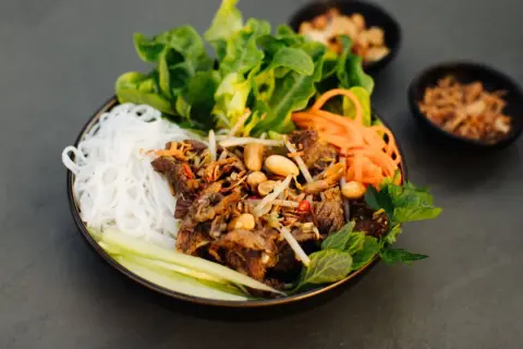 Bun bo nam bo: Reisnudeln mit Rindfleisch, Erdnüssen, Sojasprossen, Karotten und frischem Salat.