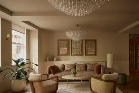 Ein Wohnzimmer im **lagom Lebensstil**: Gemütliche Sitzmöbel, dezente Farben, natürliche Materialien und Kunstwerke schaffen eine harmonische Atmosphäre.
