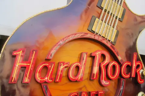Hard Rock Cafe-Schild in Gitarrenform, das an die besten Songs der 70er erinnert.