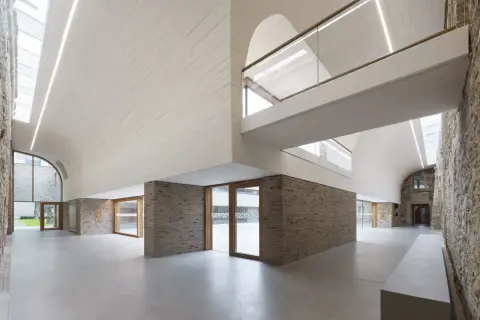 Modernes Haus Altenberg mit geschwungener Decke, Ziegelwänden und viel Glas.