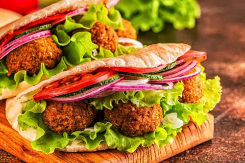 Pyszne falafel w picie z sałatą, pomidorem, ogórkiem i czerwoną cebulą. Idealna przekąska, która odpowie na pytanie: co to jest falafel?