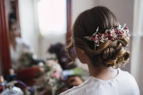Moño bajo con flores para pelo corto en una boda. Un detalle romántico para el gran día.