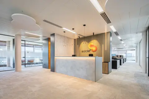 Recepción moderna con logo de "soldef" y mobiliario elegante. El diseño busca crear un ambiente de trabajo que inspire y funcione bien.