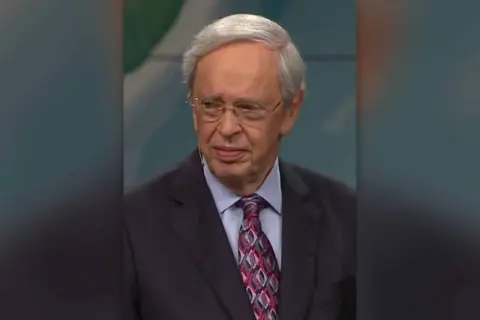 Porträt von Dr. Charles Stanley, einem älteren Mann mit Brille und grauem Haar, der einen Anzug mit gemustertem Krawatte trägt.