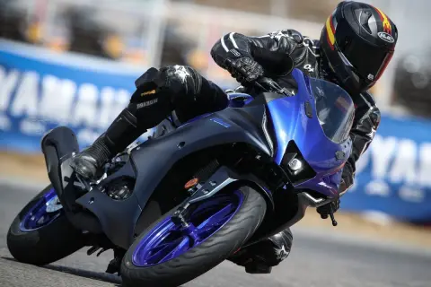 Piloto en Yamaha R125 azul inclinado en curva, demostrando su potencial de yamaha r125 top speed en pista.