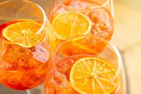 Aperol z czym pić? Orzeźwiający drink z pomarańczą i lodem w kieliszkach. Idealny na lato.