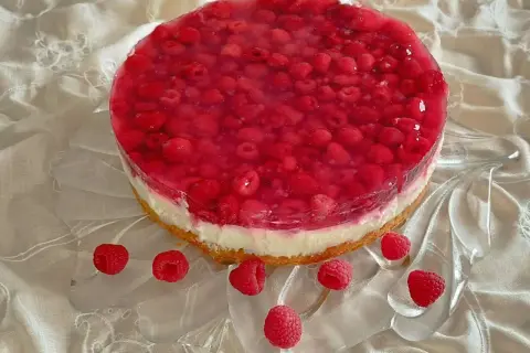 Himbeer Joghurt Torte mit frischen Himbeeren und Tortenguss auf einem cremigen Boden, verziert mit einzelnen Himbeeren.