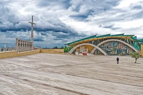 Piazza del Santuario di San Pio, il paese di Padre Pio, con la sua architettura moderna e il cielo drammatico.