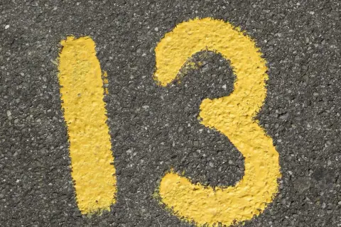 Żółta liczba 13 namalowana na asfalcie.