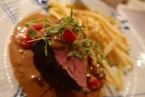 Perfekt tillagad oxfile sous vide med krämig sås, pommes frites och färska örter. En festmåltid!
