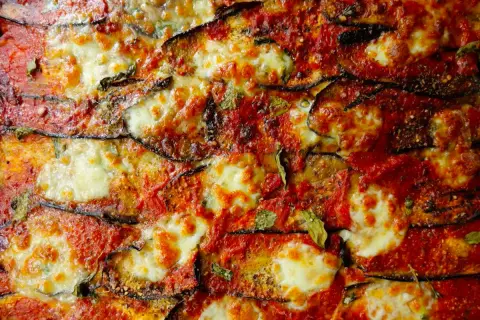 Aubergines à la parmigiana, une véritable recette italienne avec des couches d'aubergines grillées, sauce tomate et fromage fondant.