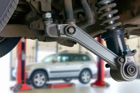 Fahrwerk eines Autos mit Stoßdämpfer und Querlenker. Möglicherweise ein Grund, warum das Auto nach rechts zieht trotz Spureinstellung.