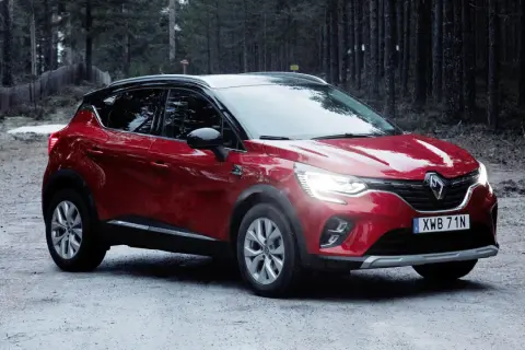 Röd Renault Captur, redo för ett begagnat test i skogen.