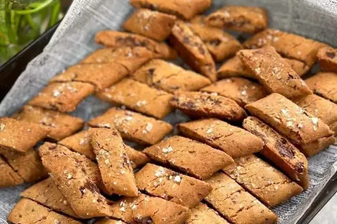 En hög med gyllene kolakakor med flingsalt, perfekta för fikat.