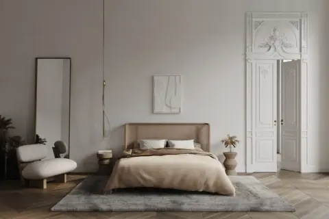 Elegancka sypialnia z łóżkiem z rattanowym zagłówkiem, dywanem i ozdobnymi drzwiami z bogatą sztukaterią w sypialni.