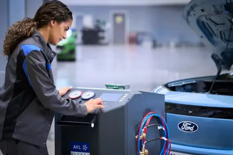 Mekaniker utför service på en Ford Focus. Maskinen indikerar att det är dags för ford focus serviceintervall.