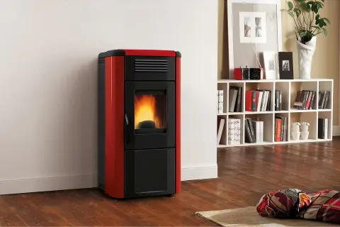 Moderner roter Pelletofen mit brennendem Feuer. Ein Blickfang, der zeigt, warum sich ein Pelletofen lohnt.