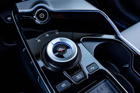 Pokrętło wyboru biegów w nowoczesnym samochodzie z napędem elektrycznym. Widoczny przycisk EV i oznaczenia R, N, D. Skrzynia biegów automat ułatwia jazdę.
