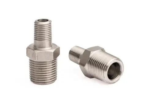 Dwa metalowe złączki hydrauliczne z gwintem 1 cal. Jedna stoi pionowo, druga leży.