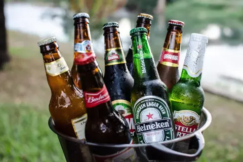 Kosz z butelkami piwa, w tym Heineken i Stella Artois, gotowy na letnie spotkanie. Idealne piwo w Niemczech na upalne dni.