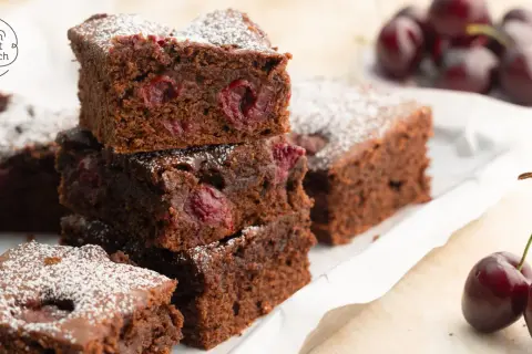 Saftiger Schoko Kirsch Kuchen vom Blech, bestäubt mit Puderzucker. Kirschen und Schokolade vereinen sich zu einem köstlichen Genuss.