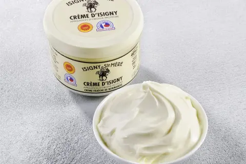 Crème d'Isigny : un pot et un bol de crème fraîche onctueuse. Parfaite pour la cuisine, sa richesse sublime vos plats.
