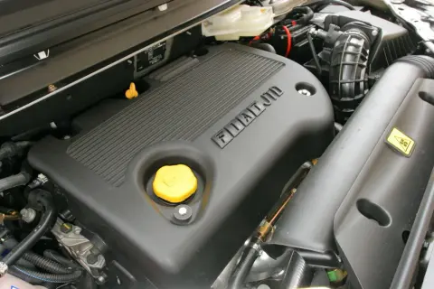 Silnik JTD Fiata z żółtym korkiem oleju i napisem FIAT JTD.
