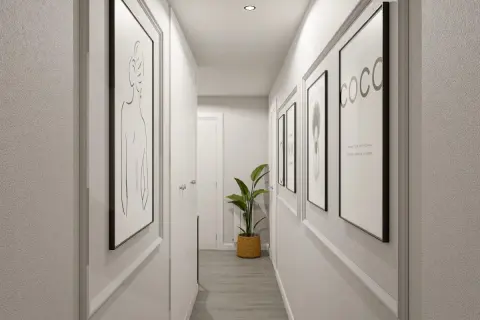 Pasillos decorados con arte minimalista y una planta verde, creando un ambiente moderno y acogedor.