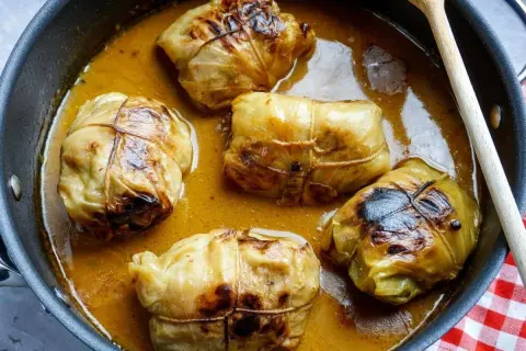 Fünf Kohlrouladen im Topf, bereit für ein köstliches Kohlrouladen Rezept.