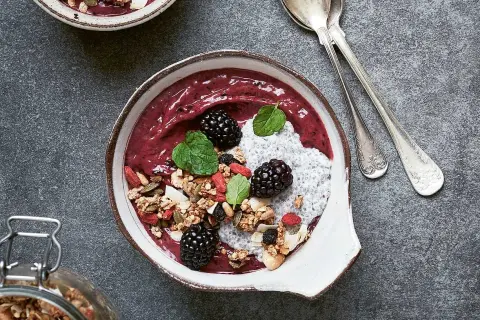 En läcker smoothie bowl med bär, granola, chiafrön och mynta. Perfekt för en hälsosam frukost eller mellanmål.
