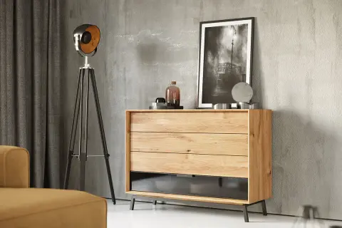 Szare ściany idealnie komponują się z beżowymi meblami, tworząc nowoczesne wnętrze. Komoda z litego drewna, lampa i obraz dodają charakteru.
