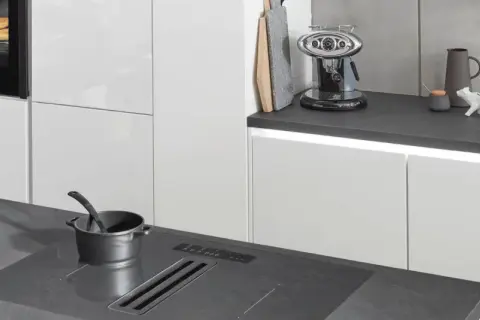 Encimeras Lamiplast en cocina moderna. Una olla espera sobre la placa de inducción integrada.
