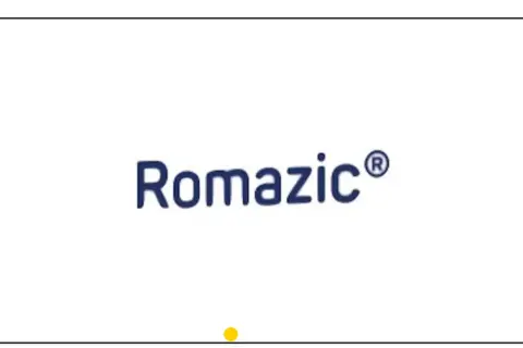 Niebieski napis Romazic® na białym tle. Mała żółta kropka pod napisem.
