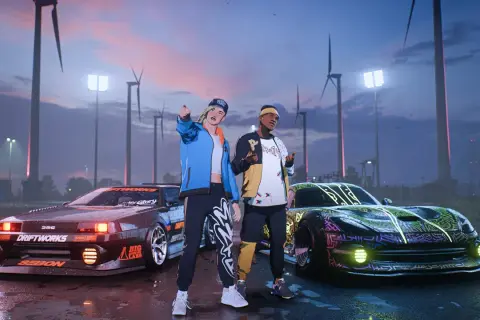 Dwóch graczy z najnowszego Need for Speed pozuje przy zmodyfikowanych autach na tle wiatraków i nocnego nieba.