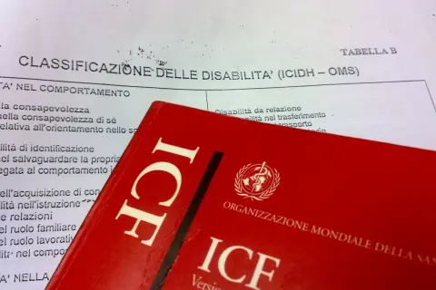 Classificazione delle disabilità (ICIDH - OMS) e copertina rossa del manuale ICF.