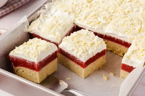 Schichtkuchen mit roter Fruchtschicht, weißer Creme und Schokostreuseln, wie von Frau Holle gebacken.
