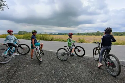 Cztery dzieci na rowerach, zastanawiają się, jaki rower dla 8 latka 20 czy 24 cali będzie najlepszy.