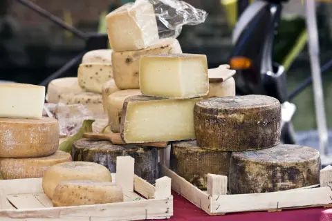 Un étalage de fromages variés, dont un beau fromage parisien, empilés et prêts à être dégustés.