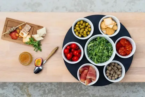 En härlig buffé med allt gott till tacos: oliver, tomater, kål, korv, skinka, köttbullar, kex, nötter och passionsfrukt.