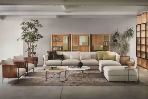 Soggiorno moderno con divano componibile color crema, poltrone in rattan e pareti color tortora chiaro e scuro.