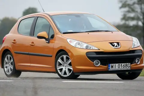 Pomarańczowy Peugeot 207 1.6 HDi na drodze.