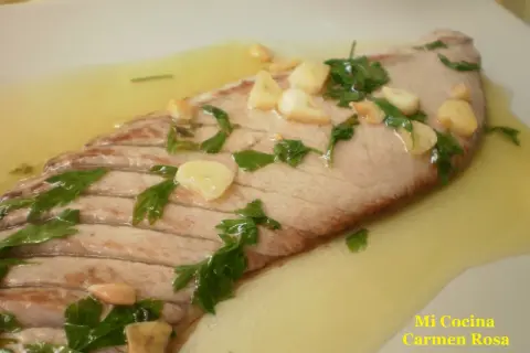 Deliciosa ventresca a la plancha con ajo laminado y perejil fresco, nadando en un sabroso aceite.